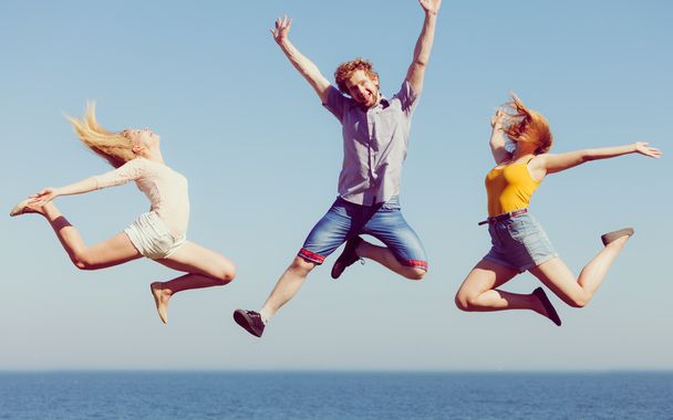 Ryhmä ystäviä hyppäämällä ulkona
 - Valokuva, kuva