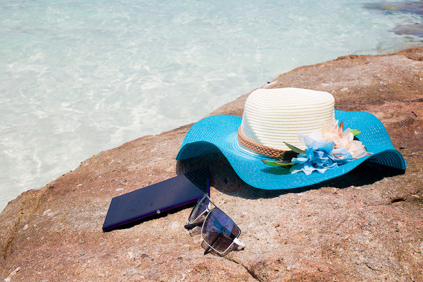 hermoso sombrero azul, móvil y gafas de sol en la piedra
 - Foto, imagen