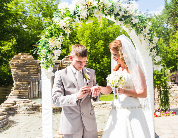 Casal se casar em uma cerimônia de casamento ao ar livre
 - Foto, Imagem