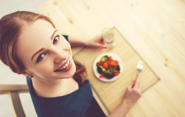 молода здорова жінка їсть овочі вдома на кухні
 - Фото, зображення