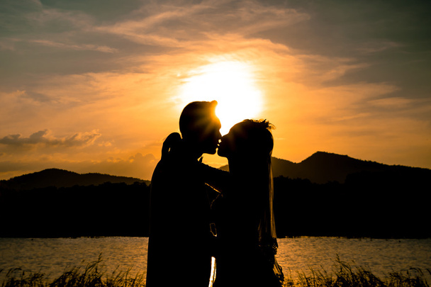 Mariée et marié baisers au coucher du soleil
 - Photo, image