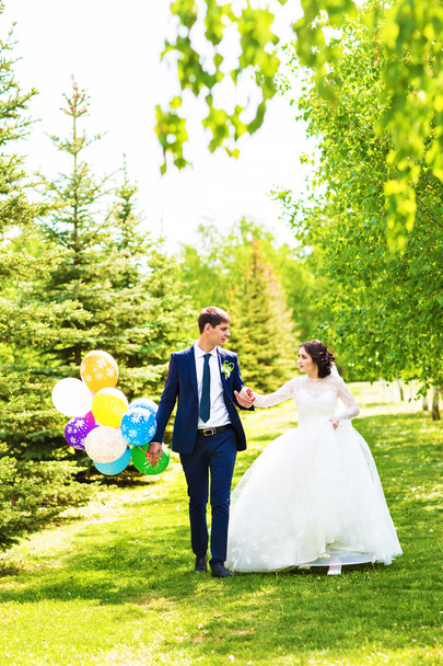 Beautiful bride and groom with colorful balloons - Photo, Image