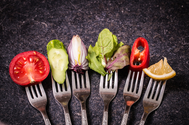 Fresh mixed vegetables on fork on black background - Foto, Imagen