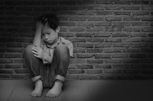 Smutny chłopiec siedzi na podłodze - Zdjęcie, obraz