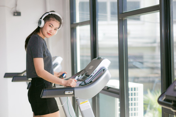 Beautiful young women exercising on a treadmill at the bright modern gym - Foto, afbeelding