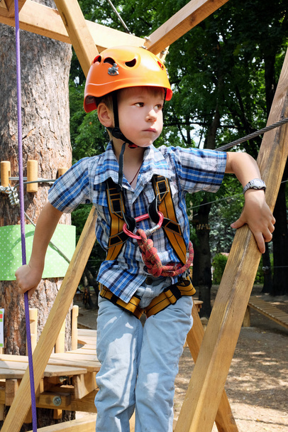 Lindo chico con equipo de escalada en un parque de aventuras
 - Foto, imagen