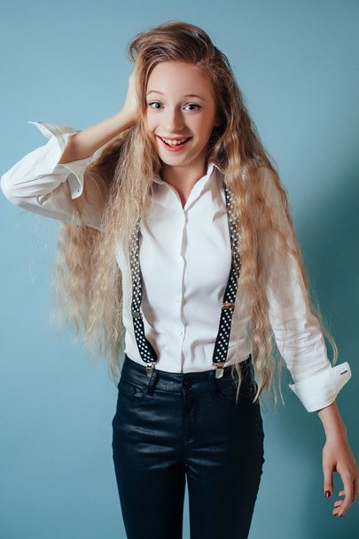 Smiling girl with long blonde hair on blue background - Valokuva, kuva