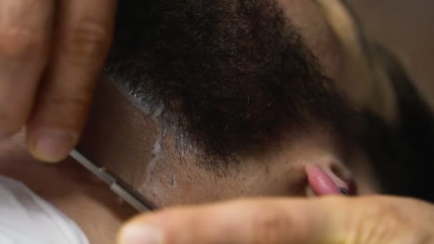 Barber shaves customers chin with straight razor slow motion close up - Materiaali, video