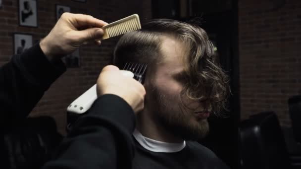 Κουρέας κόβει τα μαλλιά του πελάτη με clipper αργή κίνηση - Πλάνα, βίντεο
