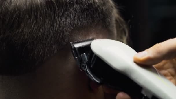Barber cuts the hair of the client with clipper slow motion close up - Footage, Video