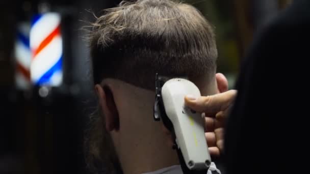 Парикмахер стрижет волосы клиента клиппером замедленным движением крупным планом
 - Кадры, видео