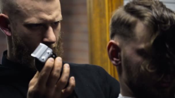 Barbeiro corta o cabelo do cliente com clipper câmera lenta de perto
 - Filmagem, Vídeo