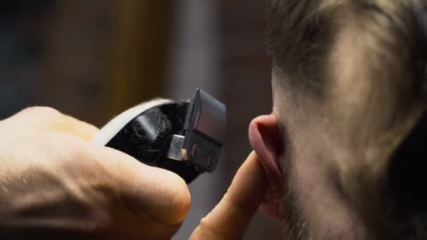 Barber cuts the hair of the client with clipper slow motion close up - Felvétel, videó