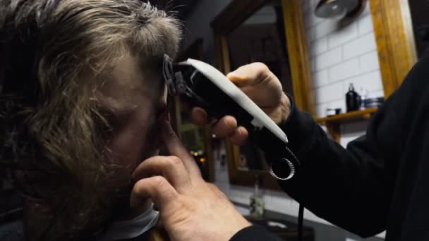 Κουρείο περικοπές από κοντά τα μαλλιά του πελάτη με clipper αργή κίνηση - Πλάνα, βίντεο