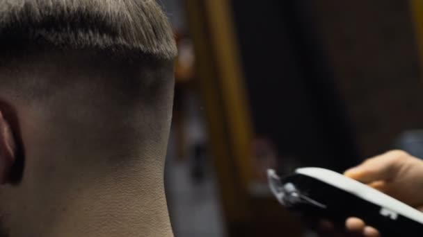Holič střihy vlasy klienta s clipper zpomalené zblízka - Záběry, video