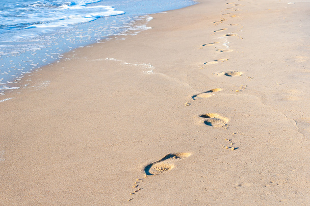 Impronte sulla sabbia al tramonto. Concetto viaggio estivo
 - Foto, immagini
