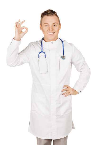 Fiatal férfi orvos fehér kabátot és sztetoszkóp ok kéz mutató  - Fotó, kép