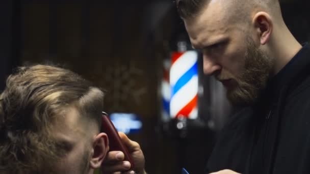 Barbeiro corta o cabelo do cliente com aparador câmera lenta
 - Filmagem, Vídeo