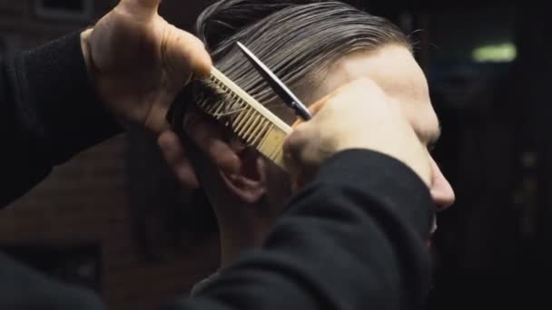 Barber cuts the wet hair of the client with scissors slow motion - Video