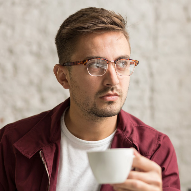 Man wearing eyeglasses drinking coffee - Fotoğraf, Görsel