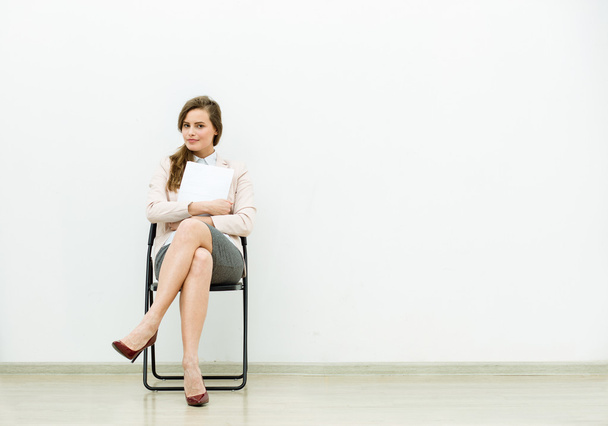 woman in office outfit waiting on a chair - Foto, Bild