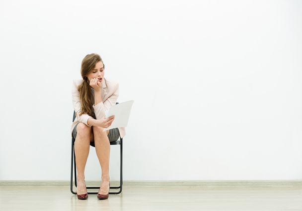 woman in office outfit waiting on a chair - Фото, изображение