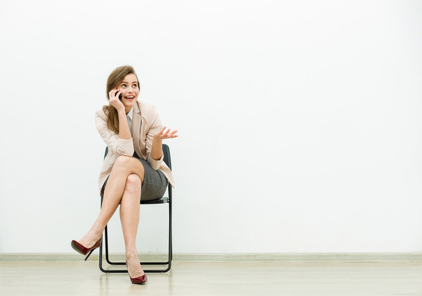 woman in office outfit waiting on a chair - Fotoğraf, Görsel