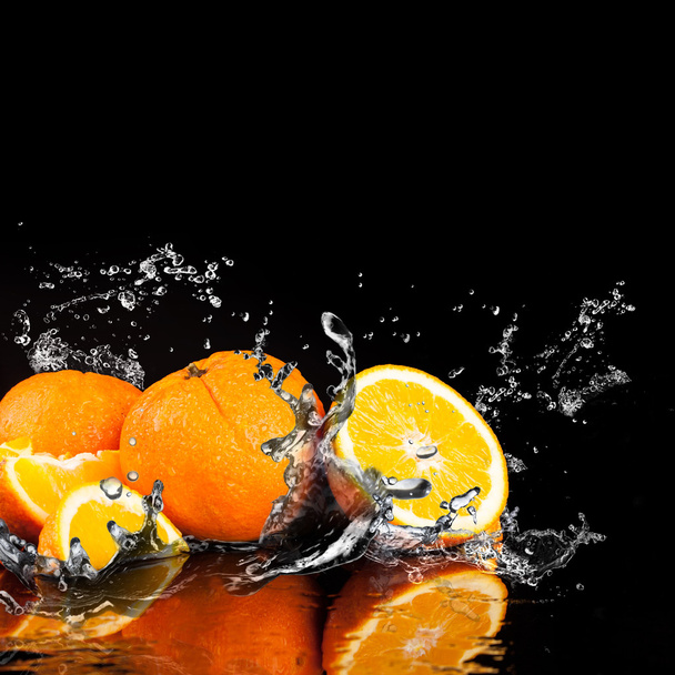 Frutas de naranja y agua salpicada
 - Foto, Imagen