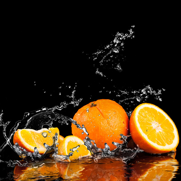 オレンジ色の果実と水しぶき水 - 写真・画像
