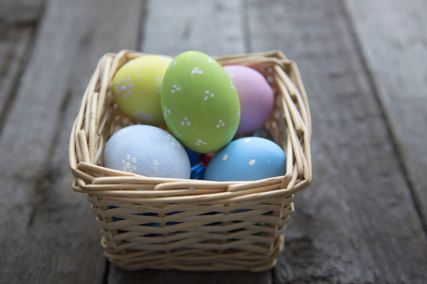 Ovos de Páscoa na cesta de tábuas de madeira
 - Foto, Imagem