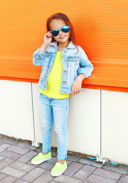 Beautiful little girl child wearing a sunglasses and jeans cloth - 写真・画像