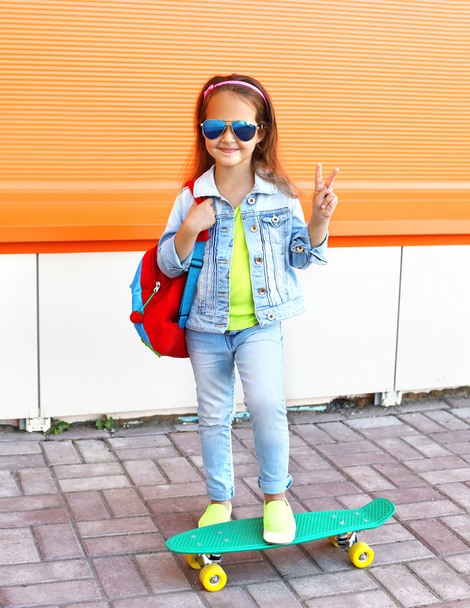 Stylish little girl child with skateboard in city - 写真・画像