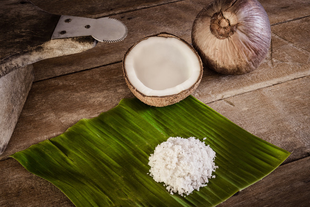 Orzechy kokosowe i płatki kokosowe na banana leaf i kokosowe tarka - Zdjęcie, obraz