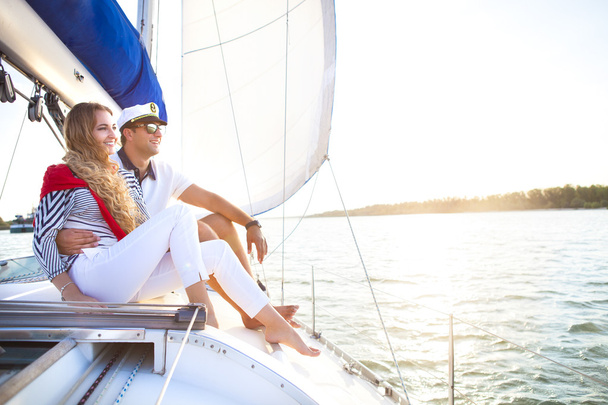 Jovem casal sorridente em um barco à vela no verão
 - Foto, Imagem