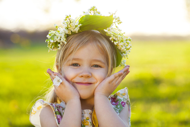 Cute little girl with blond hair in a wreath of lily of the vall - Photo, Image