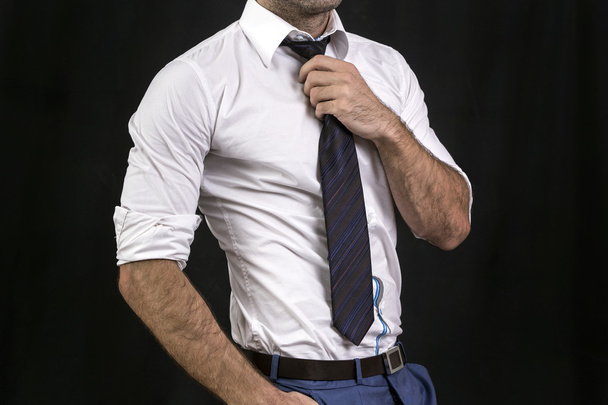 Businessman holding his tie - Foto, afbeelding