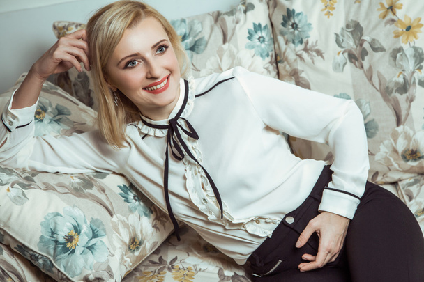 Beautiful young fashion caucasian blonde model posing on sofa. - Zdjęcie, obraz