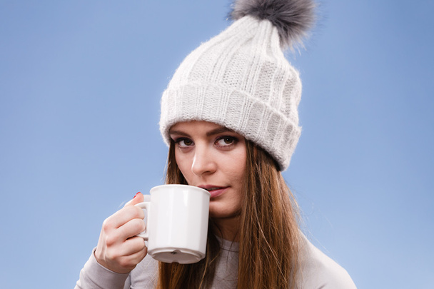 woman in winter wool cap drinking tea - Фото, изображение