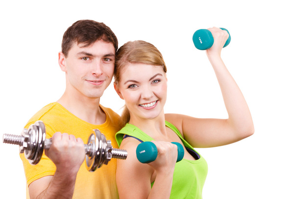Couple exercising with dumbbells lifting weights  - Valokuva, kuva
