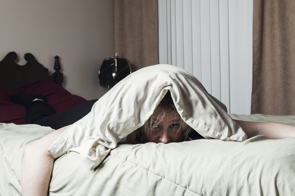 A woman feel sick lying down on bed - Photo, Image
