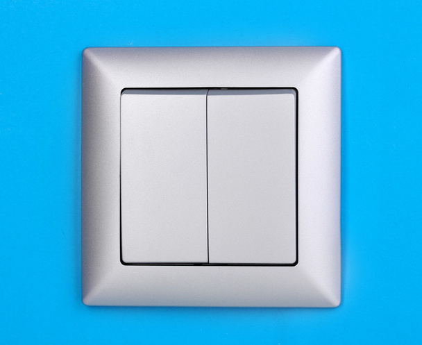 Modern light switch on blue background - Фото, зображення