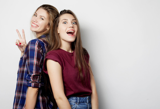Two young girl friends standing together and having fun. - Photo, image