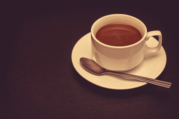 Šálek kávy s lžící na stole - Fotografie, Obrázek