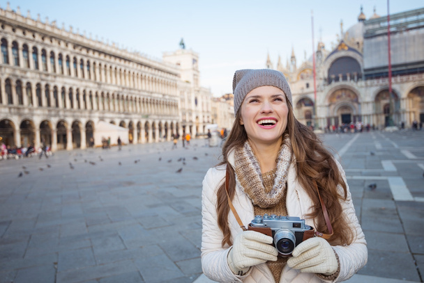 Woman holding photo camera on Piazza San Marco and looking up - Φωτογραφία, εικόνα