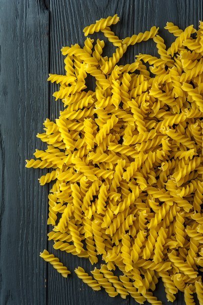 Fusilli pasta on a old wooden background. Italian cuisine. - Fotografie, Obrázek