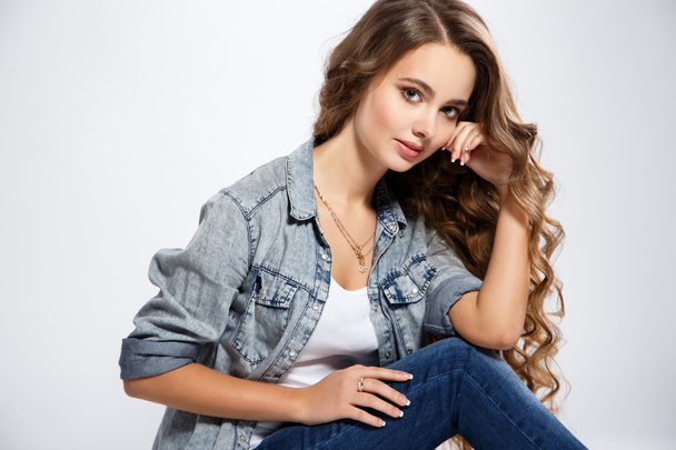 Close-up portrait of beautiful young woman with gorgeous hair and natural makeup wearing casual clothes. Fashion beauty photo, casual jeans style - 写真・画像