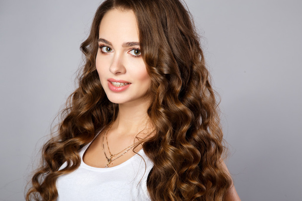 Close-up portrait of beautiful young woman with gorgeous hair and natural makeup. Fashion beauty photo - Фото, зображення