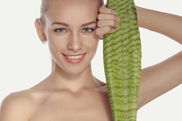 Girl holds a large and long green leaf and smiling.  - Fotoğraf, Görsel