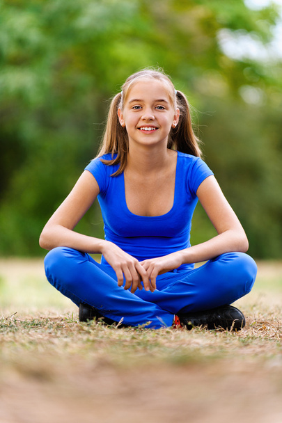 Teenage girl sitting in lotus position - Photo, Image