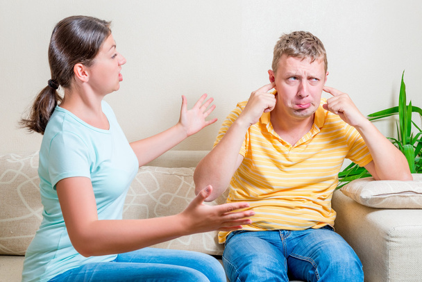 esposa repreende seu marido sentado em um sofá na sala de estar
 - Foto, Imagem